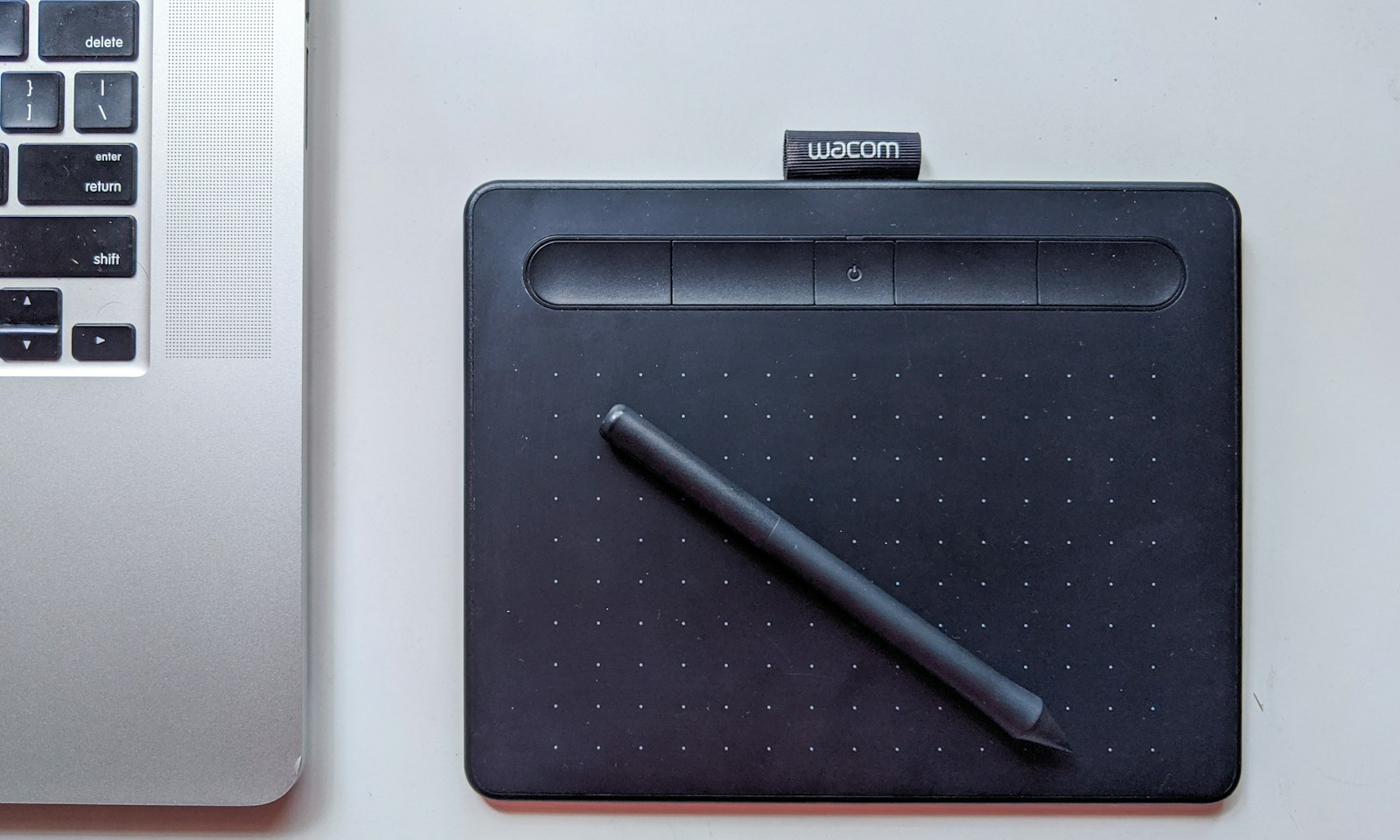 Tablet piórkowy Wacom Intuos z piórkiem obok klawiatury laptopa